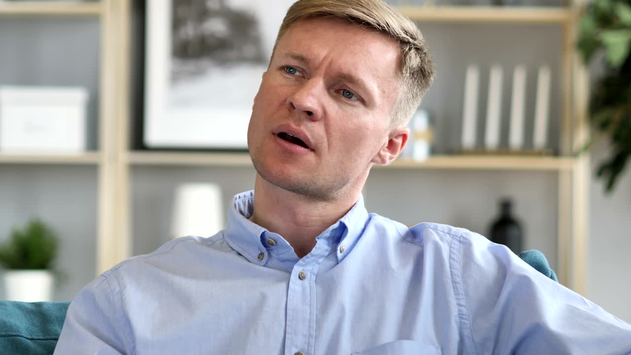 Tired Man Yawning while working on Laptop