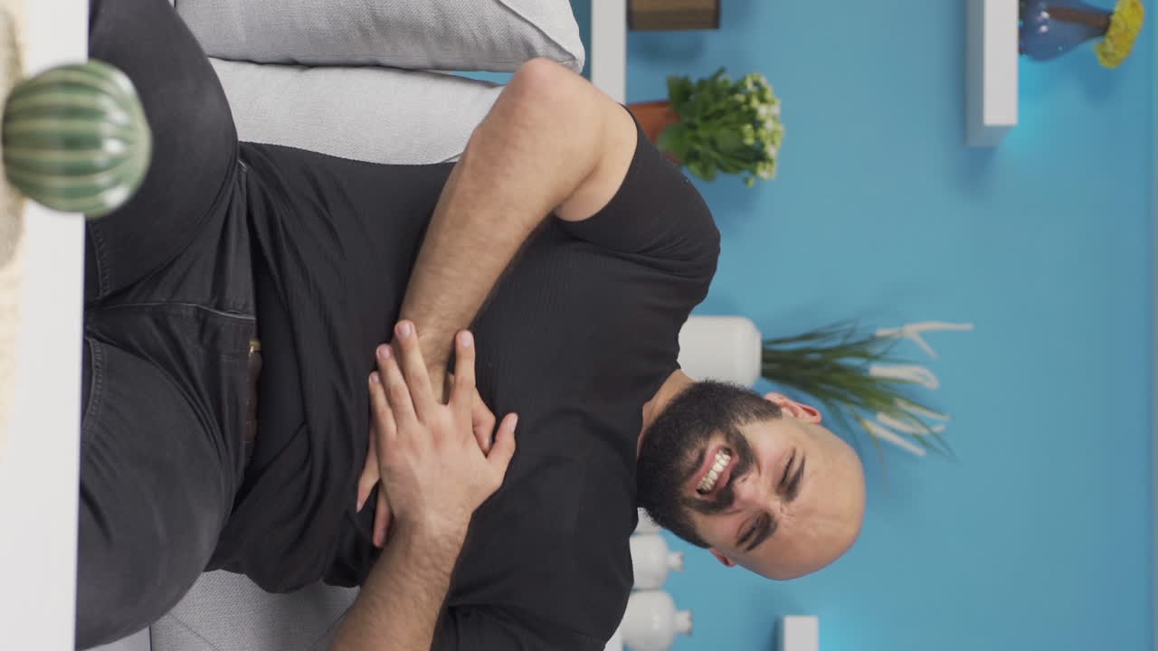 video vertical de un hombre con dolor de estómago.