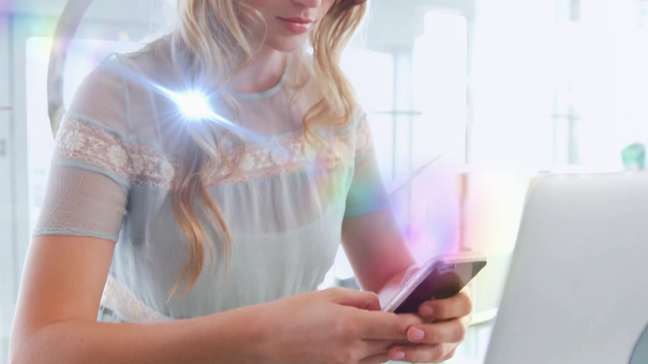 Woman using smartphone beside laptop in home office, featuring animated marketing graphs