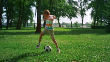 Energetic-boy-warming-up-before-football-match.-Focused-child-play-on-field.