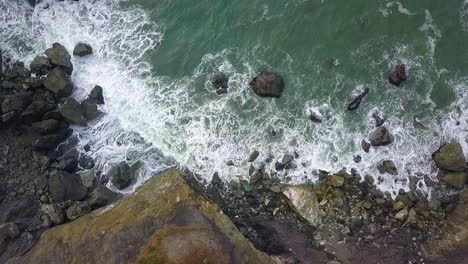 vista aerea a volo d'uccello della costa rocciosa nord-occidentale del pacifico, onde che si infrangono e mari verdi