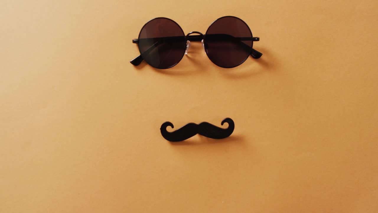video de bigote falso y gafas de sol redondas sobre fondo amarillo con espacio para copiar.