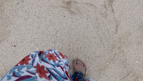 feet walking on sand into gentle waves