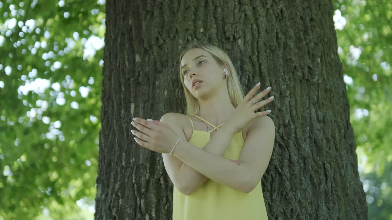 여름 공원에서 나무 에서 춤을 추는 노란색 드레스를 입은 여자