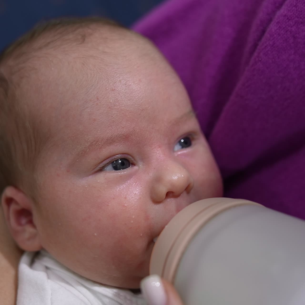 Adorable newborn baby being fed from the bottle. Mother holding her child in arms and feeding it from the bottle. Close up