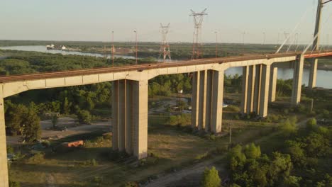 Aerial-panning-shot-revealing-Zarate-Brazo-Largo-bridge-in-Argentina-at-golden-hour