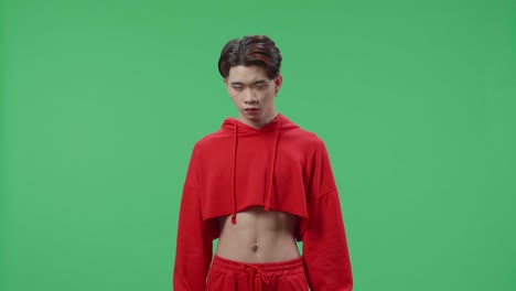 terrible asian transgender male looking at camera in the green screen studio