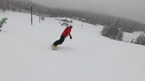 snowboarders riding down a hill