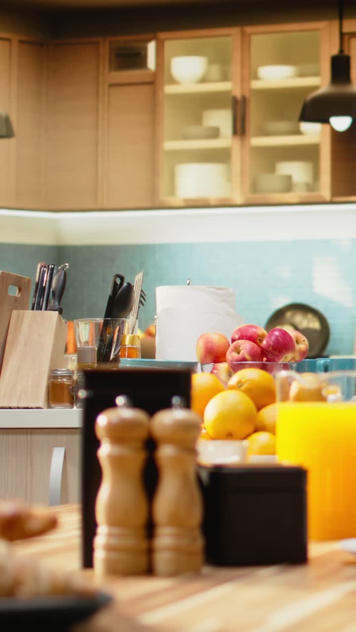 Vertical Video Kitchen with wooden breakfast table with pastry and fruits in empty home