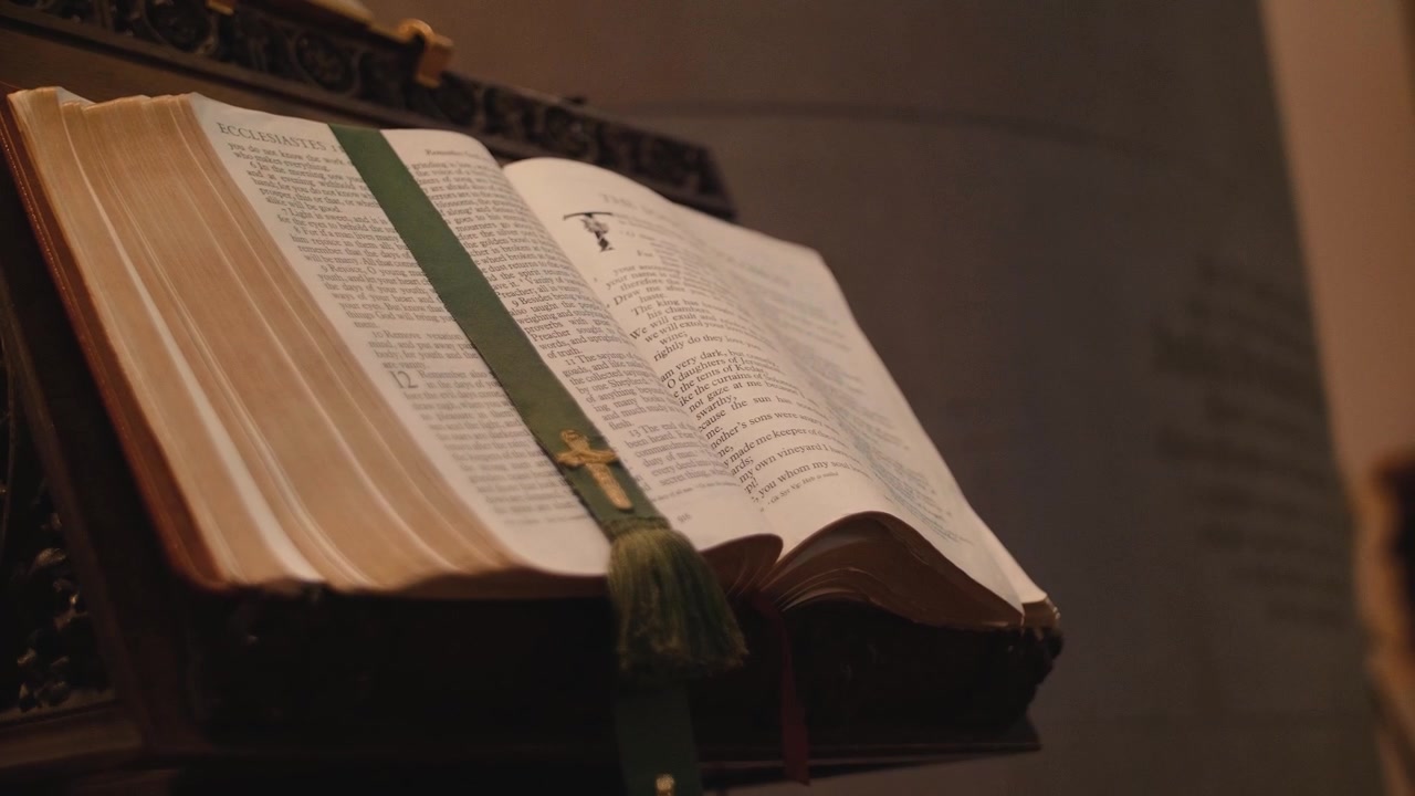 Primo piano di una Sacra Bibbia aperta su un leggio di legno