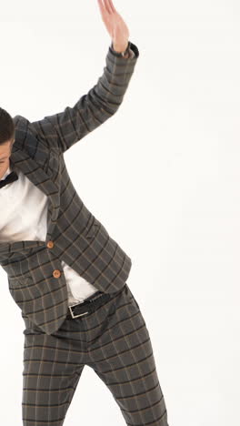 a showman in a plaid suit and white shirt is parodying a businessman with his manners on a white background in the studio vertical video
