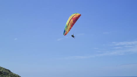 Escena-De-Vuelo-En-Tándem-De-Parapente-Con-Gente-Divirtiéndose-En-El-Cielo-Y-Haciendo-Acrobacias-Aéreas-De-Deportes-Extremos-En-Las-Playas