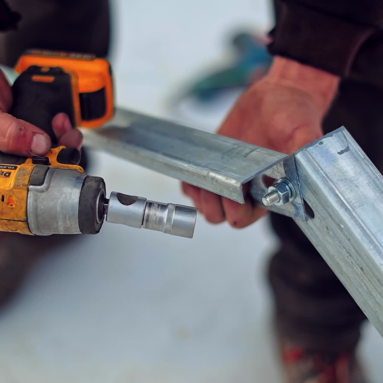 Engineers installing basis for solar panels. Worker's hands is attaching metal frame with a drill. Close-up.