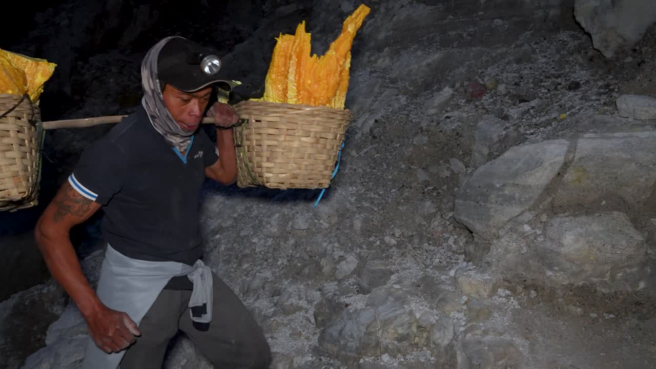 Indonesian carrying pieces of sulfur at night in the Kawah Ijen volcano