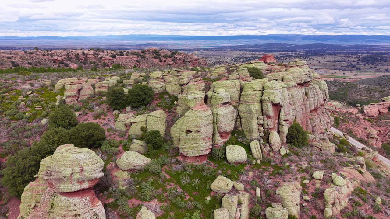 Sandstone cliffs and rock formations covered with lichen in Guadalajara province, Spain, with sweeping views of the surrounding landscape and cloudy sky