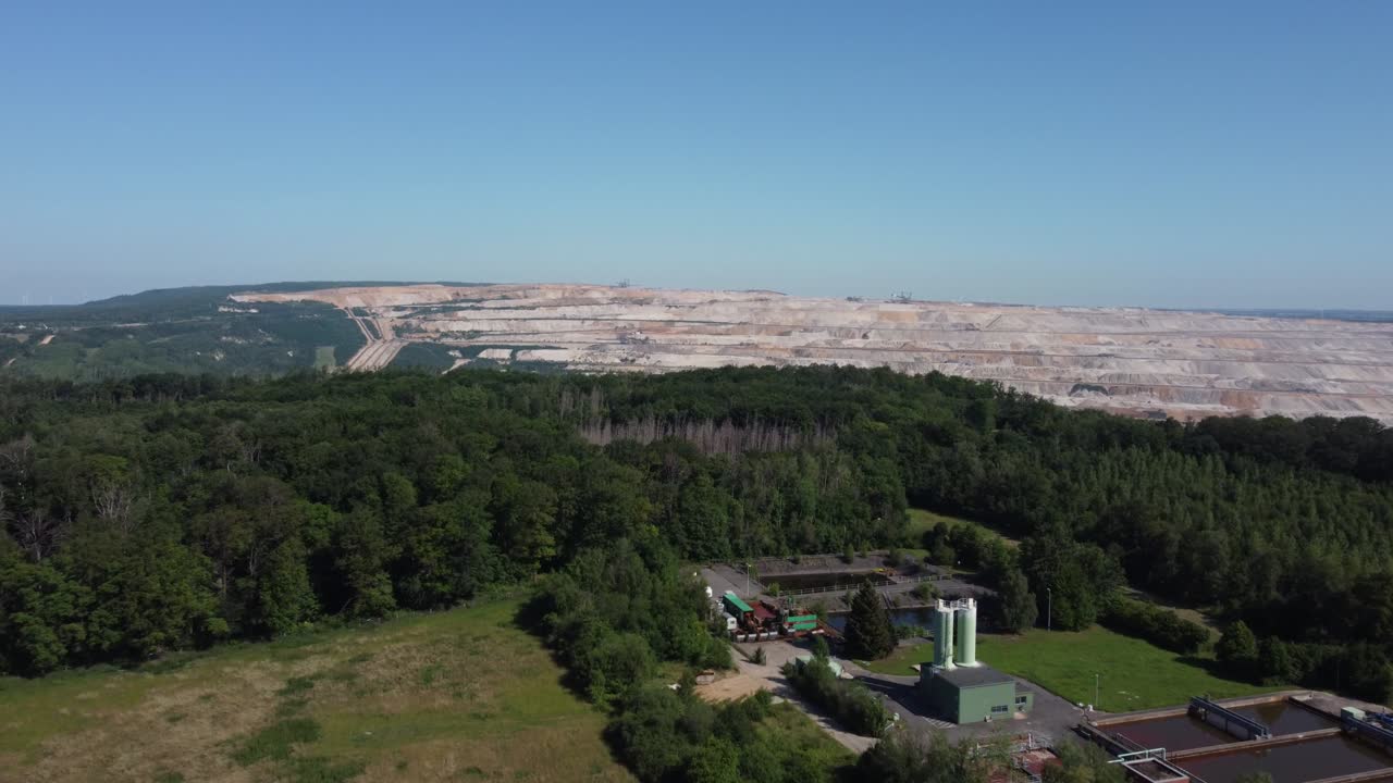 Opencast lignite mine in the Rhenish lignite mining area near Düren, Aerial flying from the forest