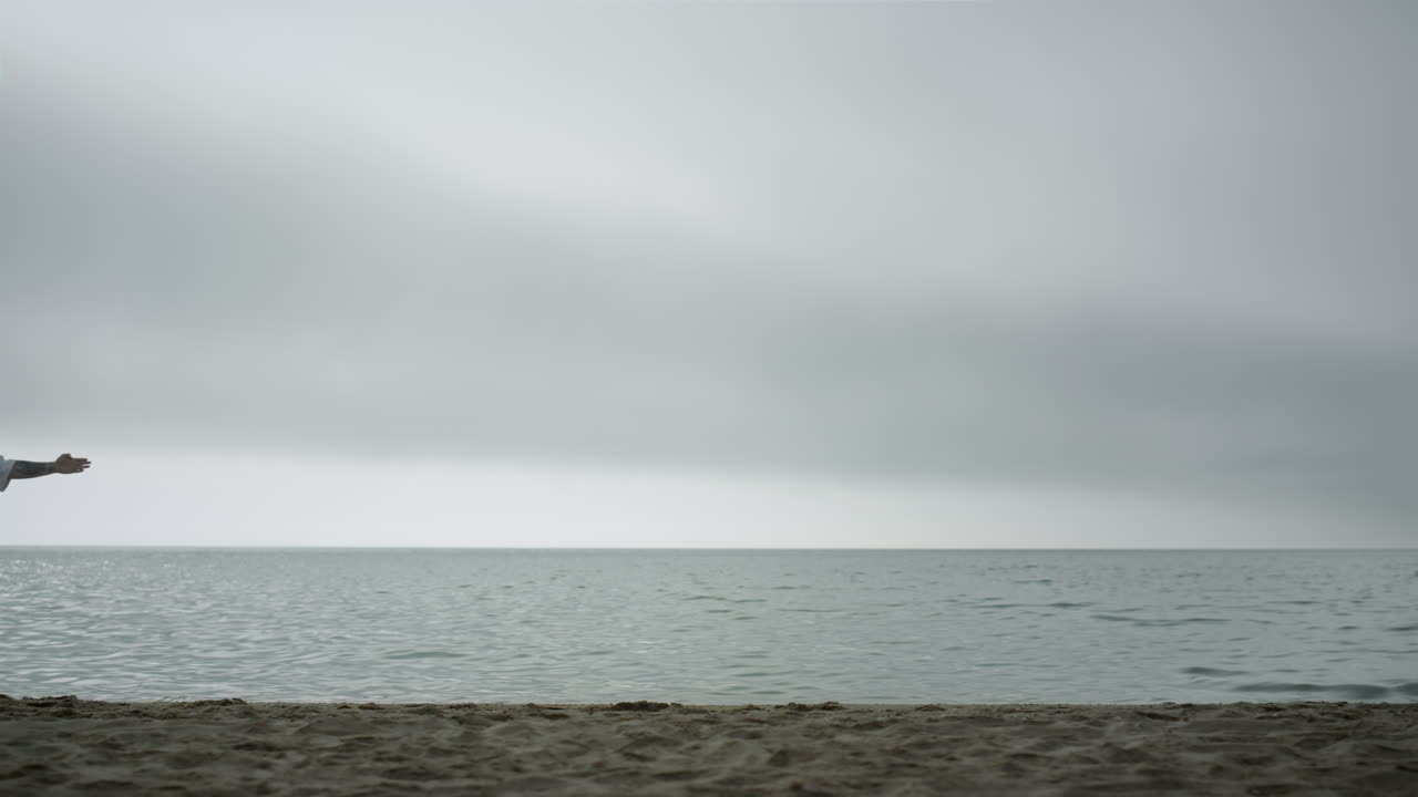 un deportista de taekwondo perfeccionando su técnica marcial en la costa.