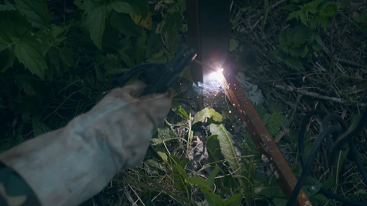 천천히 움직이는 수공예가 식물에 의해 울타리 바닥에 판을 용접합니다.