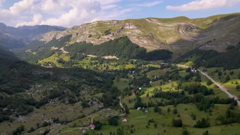 drone flight over lush mountain valley and river in montenegro