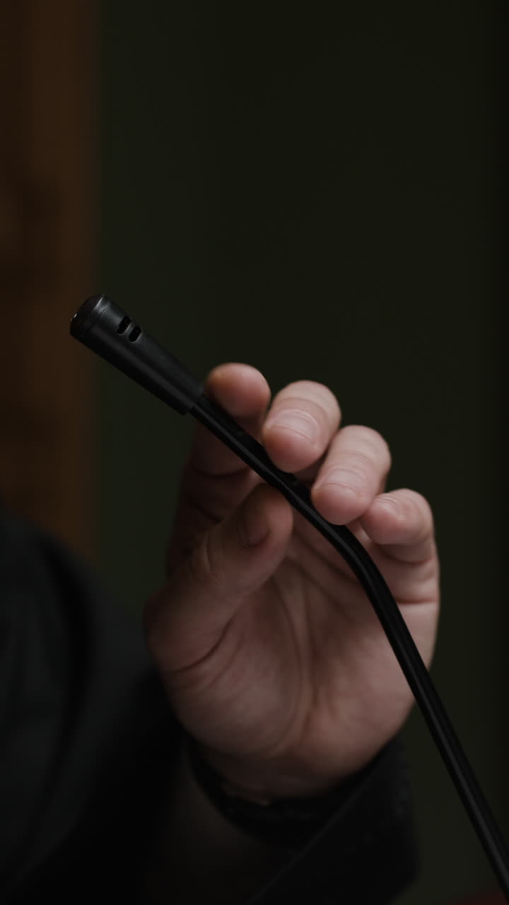 Mano sosteniendo un micrófono