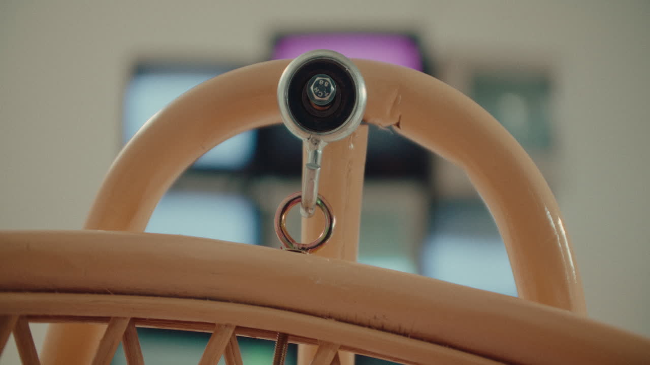 cradle baby infant newborn swinging in front of television monitor in blurred background
