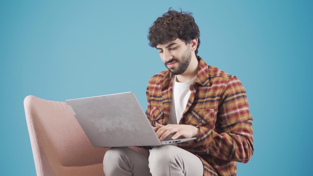 joven usando una computadora portátil escribiendo algo en el teclado, preparando texto, enviando mensajes de texto, enviando correo.