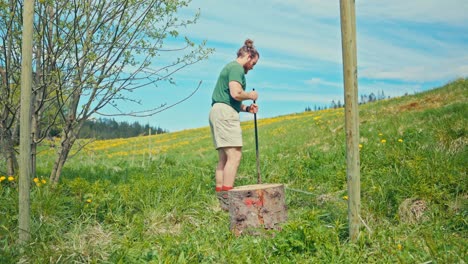 man digging holes while building wooden fence in norway - wide shot