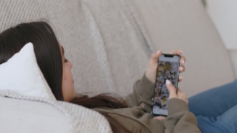 woman relaxing on couch, using smartphone