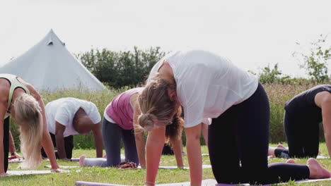 female teacher leading group of mature men and women in class at outdoor yoga retreat