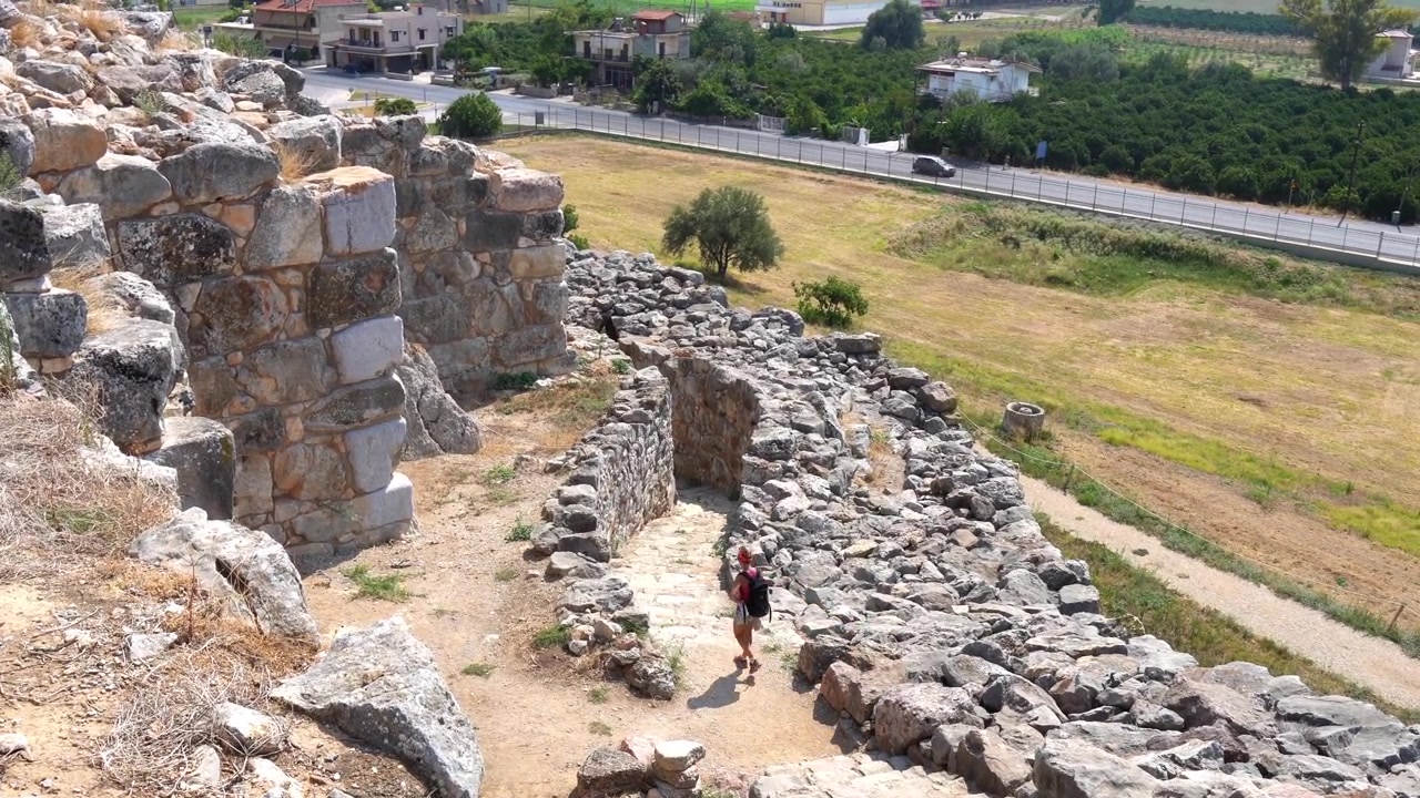 Viaggiatrice che esplora le antiche rovine dell'acropoli di Tirinto in Grecia