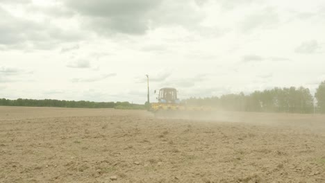 tractor con plantadoras de precisión especiales, el sembrador está trabajando en el campo, la maquinaria agrícola está plantando maíz o semillas de girasol en tierras recién aradas.