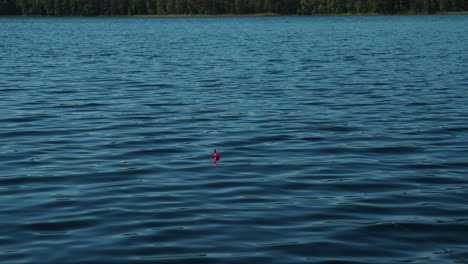 Flotador-De-Pesca-Rojo-En-Un-Lago-Profundo