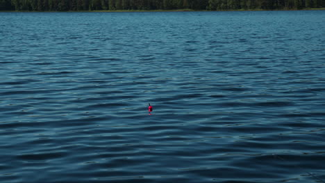 flotador de pesca rojo en un lago profundo