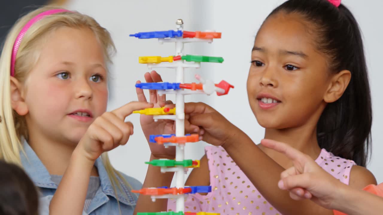 vista frontal de escolares de raza mixta estudiando sobre la estructura del adn en el aula 4k