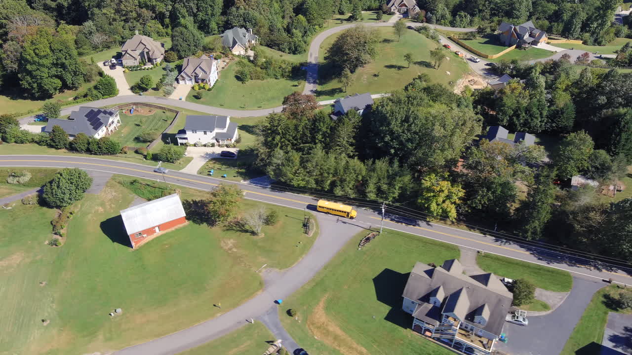 미국 노스캐롤라이나 주 애슈빌 근처 레스터 타운십에 있는 집을 통해 고속도로를 달리는 노란색 스쿨버스와 자동차의 공중 전망