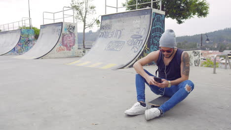 young boy using cell phone on a skate park