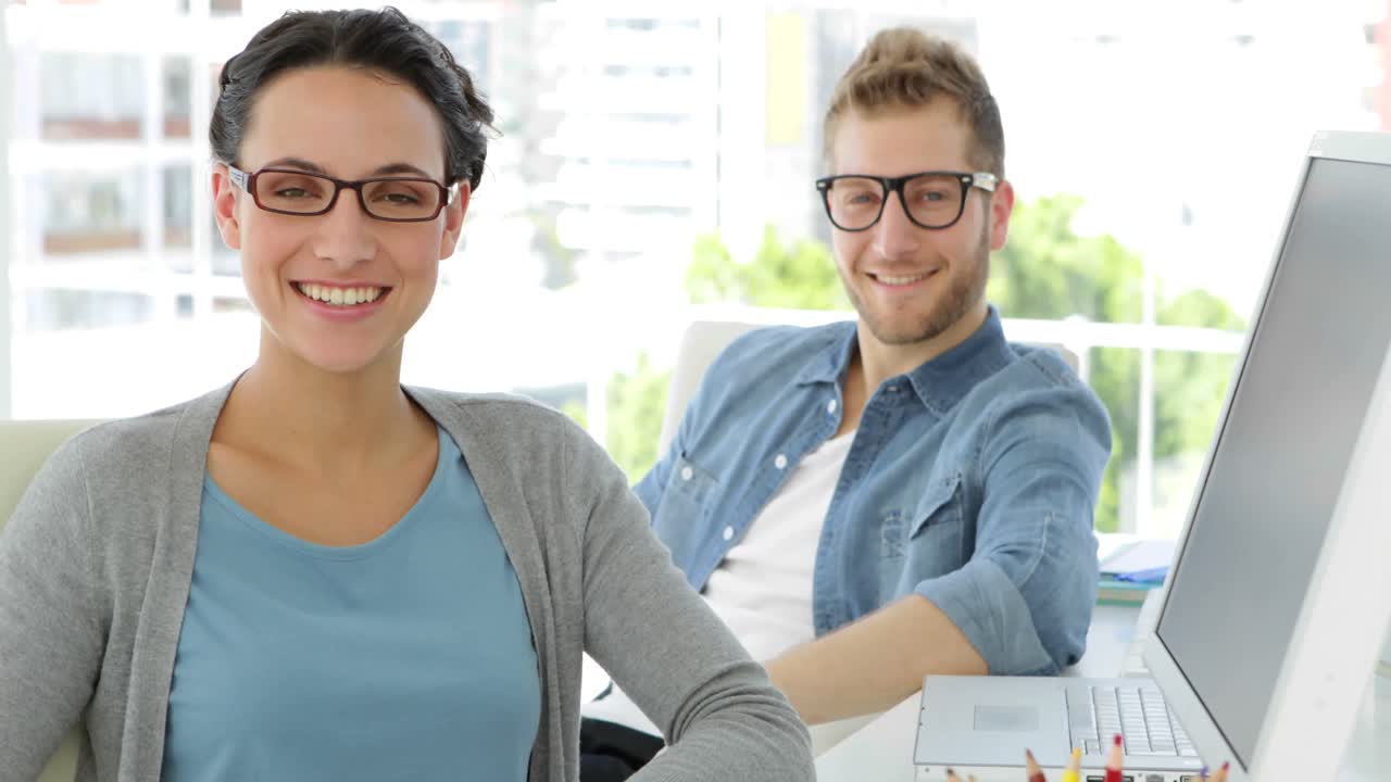encantadores compañeros de trabajo sonrientes mirando a la cámara