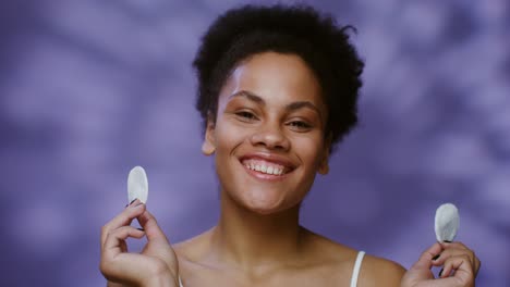 smiling woman holding cotton pads