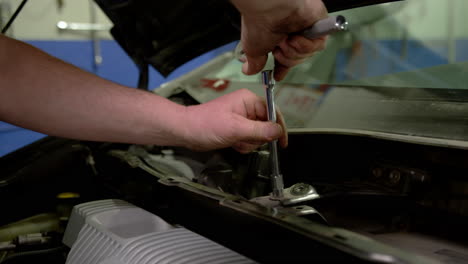 car mechanic at repair service station inspecting car suspension detail