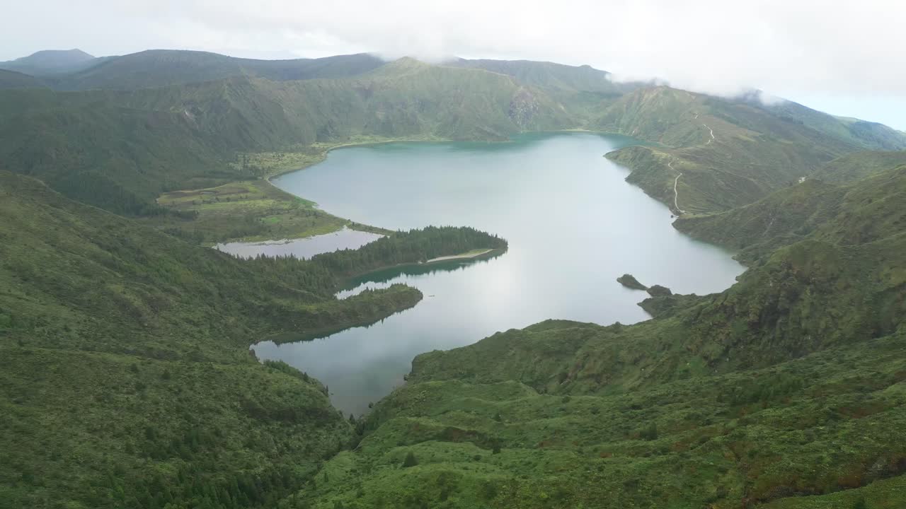 아조레스 제도 에 있는 조용 한 화산 크레이터 호수 인 라고아 도 푸고 (lagoa do fogo) 를 둘러싸고 있는 푸른 산 들