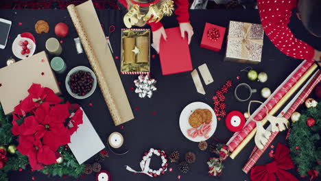 a man and woman wrapping christmas gifts together