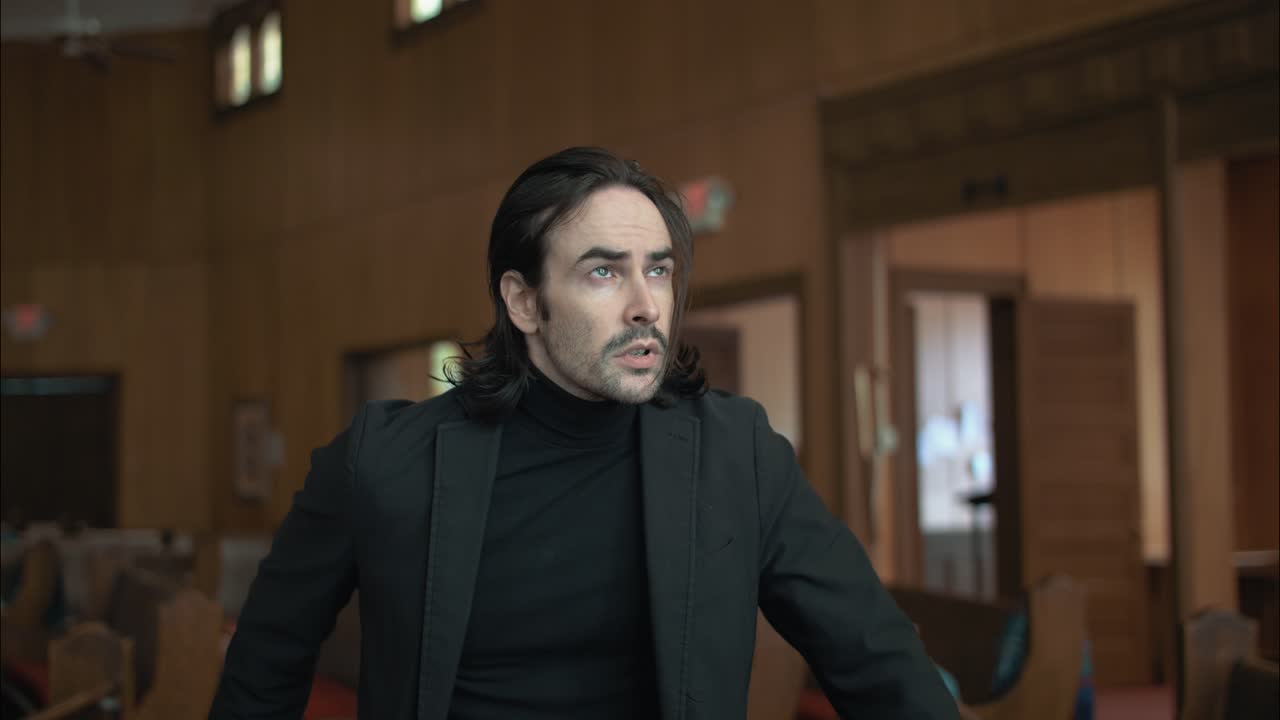 A sombre and reflective Christian man, priest, preacher, pastor in spiritual reflection and worship while praying inside old church building, creating a cinematic and contemplative mood