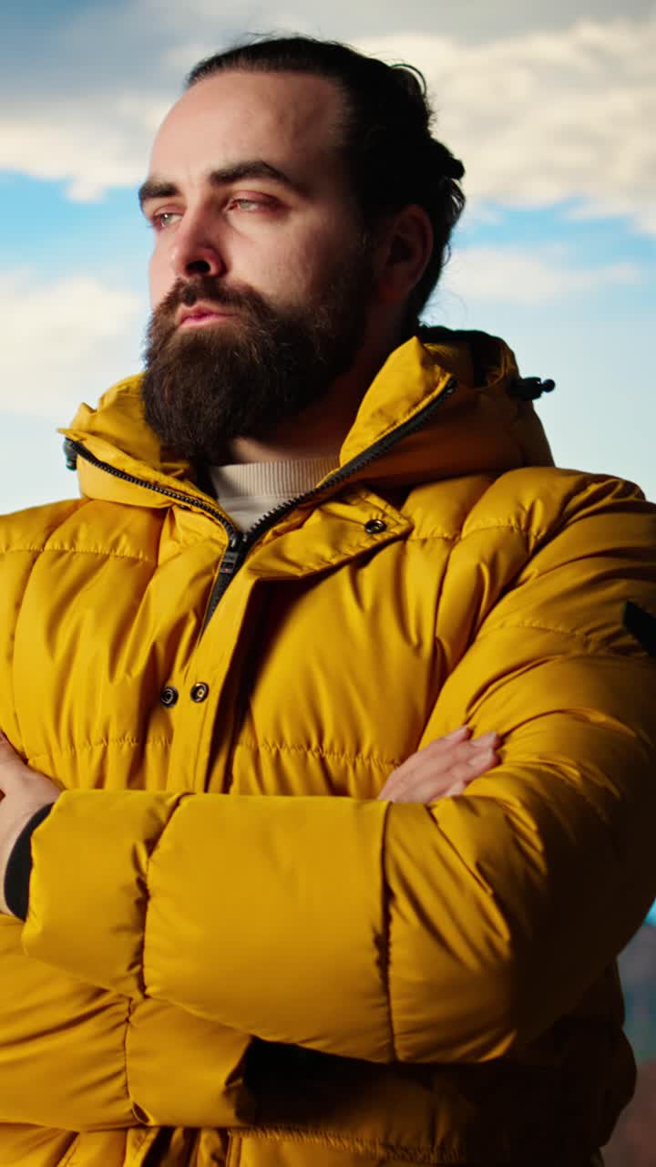 Confident Hiker Standing on Mountain Peak in Yellow Jacket