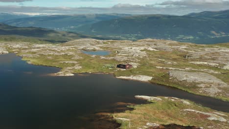 a small wooden hut on the shore of the mountain lake in the korgfjellet mountain range