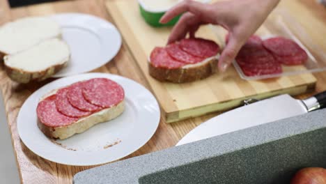 preparing a salami and cream cheese sandwich