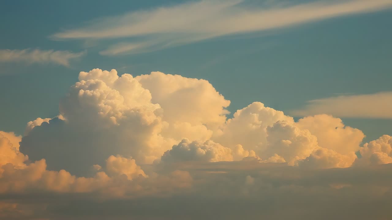 Rising cumulonimbus cloud dominating sky horizon, sun sinking casting golden then crimson hues