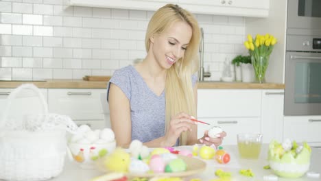 Cheerful-woman-painting-Easter-eggs