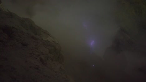 a natural phenomenon known as 'blue fire" seen through volcanic gasses coming out of the ground at the ijen volcano on the java island, indonesia