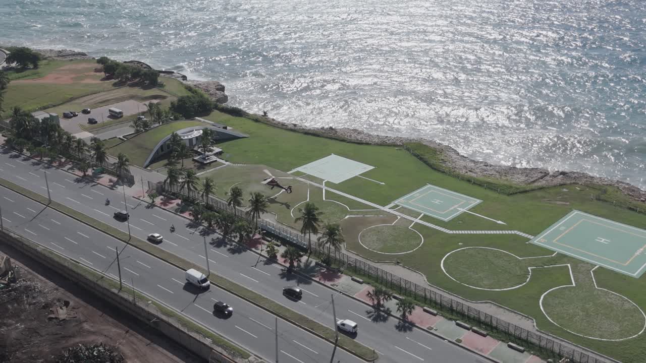 Coastal park with helipad, helicopter landing, highway, Santo Domingo in Dominican Republic. Aerial drone view