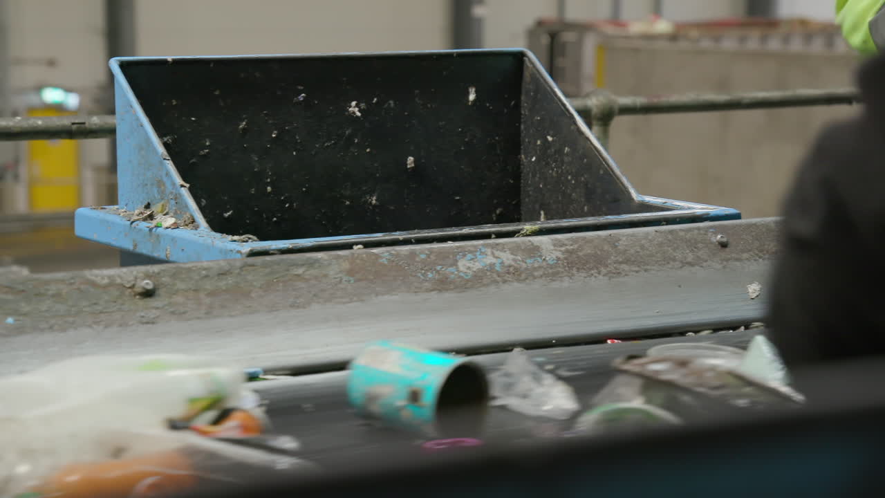 People sorting Plastic Bottles and Aluminum Cans on a Conveyor Belt in a Recycling Plant